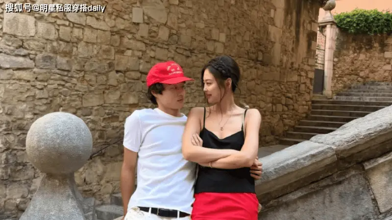 Jennie黑吊带搭配红缎短裙，编发造型走甜美又高级的路线